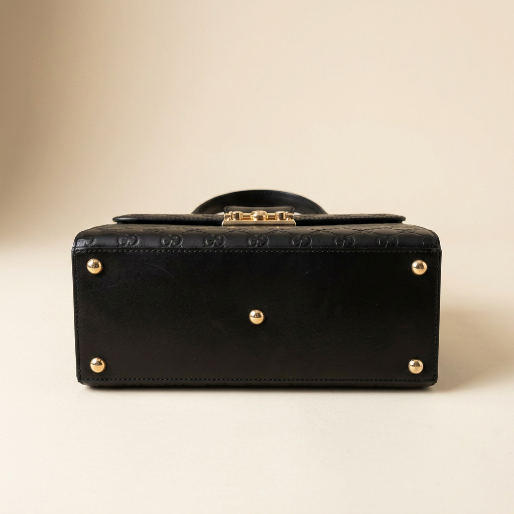 Gucci black GG embossed top handle bag bottom with gold feet